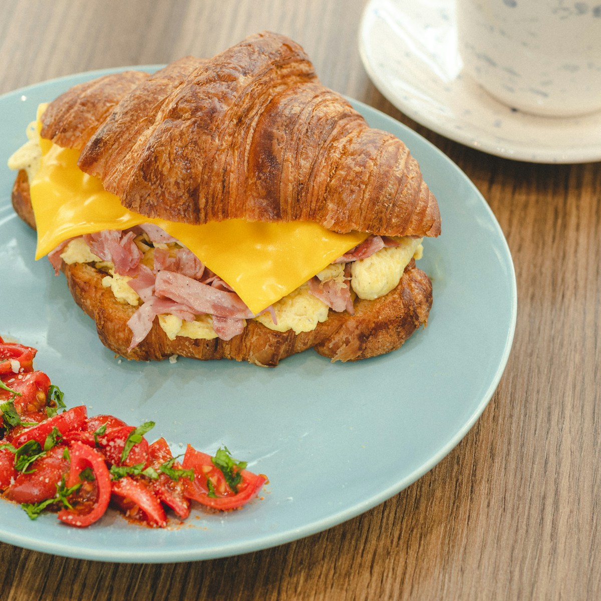 a croissant sandwich is on a blue plate